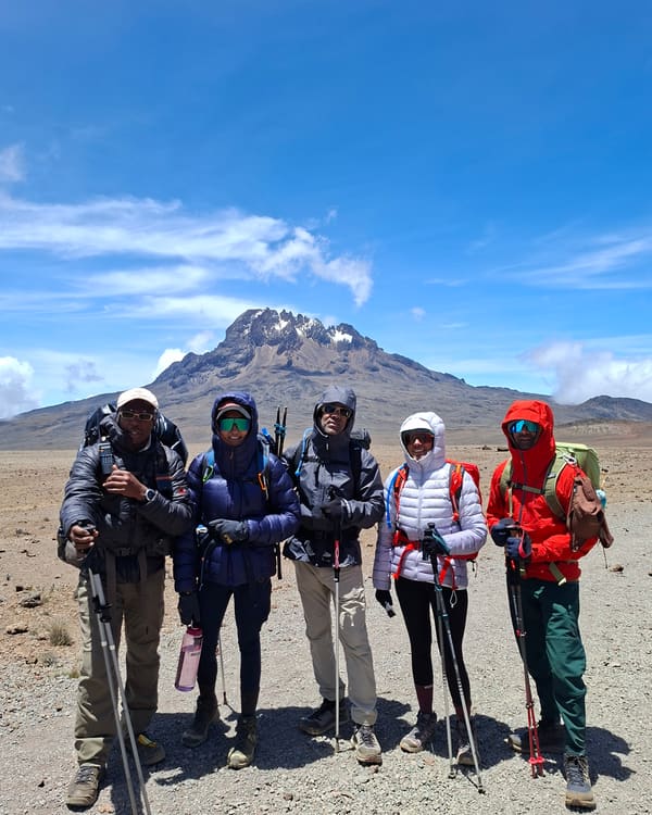 Guides and climbers on the Saddle, the alpine-desert plain below the jagged Mawenzi Peak.
